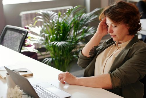 A woman feeling nauseous while intermittent fasting, holding her stomach