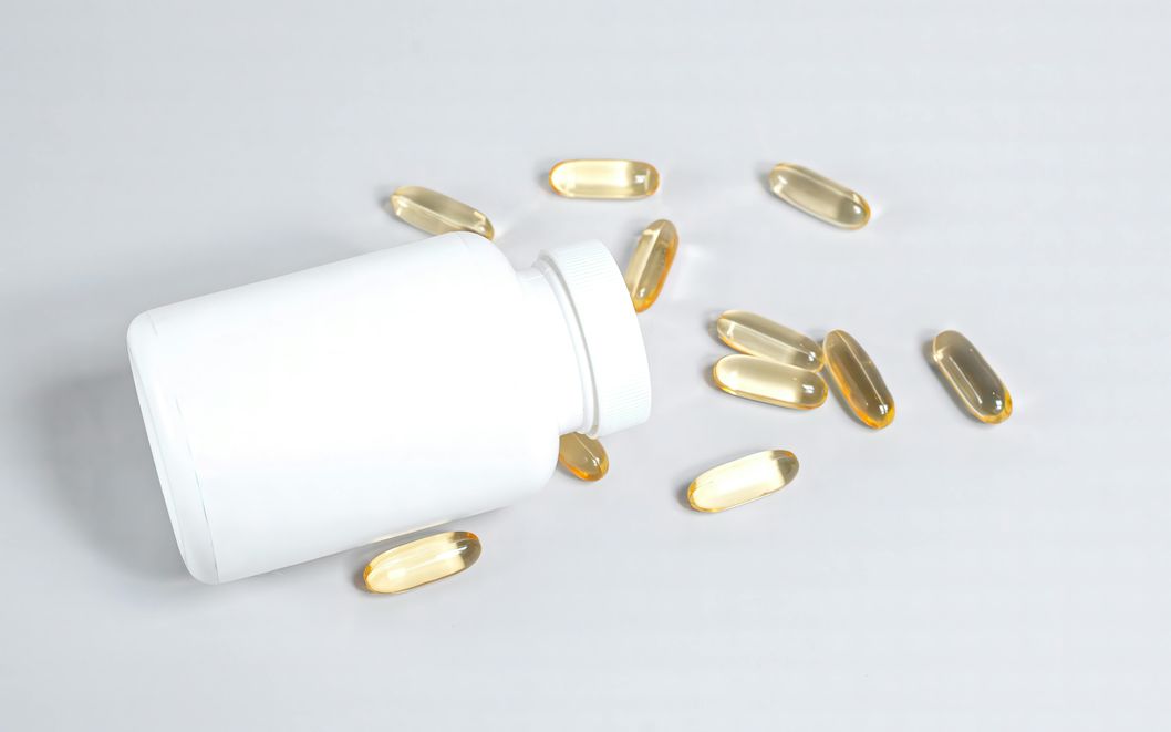 Omega-3 Supplements and Intermittent Fasting - Do They Break Your Fast? A woman taking an omega-3 fish oil supplement pill while intermittent fasting, highlighting the balance between nutrient needs and fasting goals
