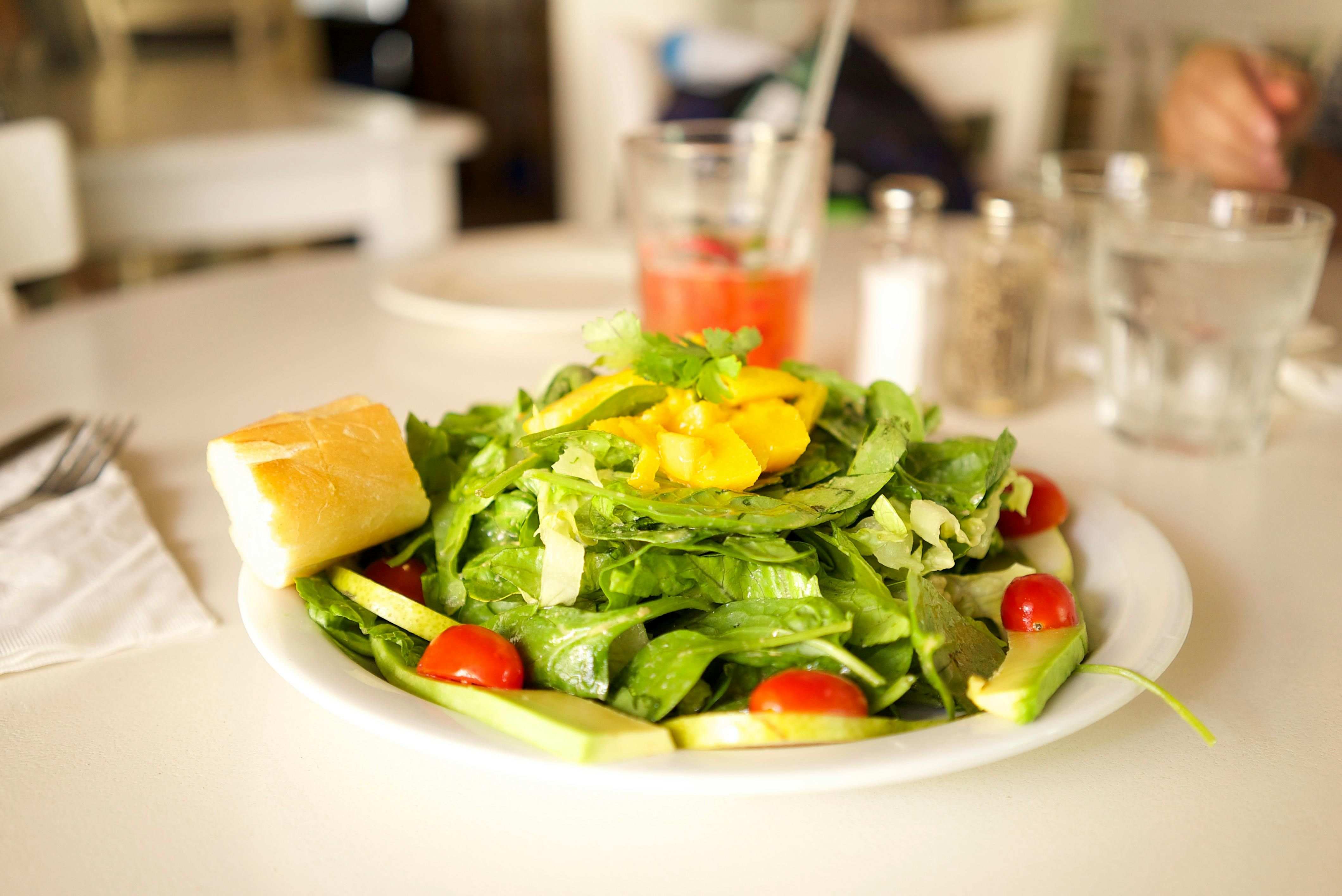The Essence of Anti-Inflammatory Eating: A Nutrient-Rich Salad for Women's Wellness A freshly prepared healthy salad featuring mixed greens, colorful vegetables, and a sprinkle of seeds on a light background.