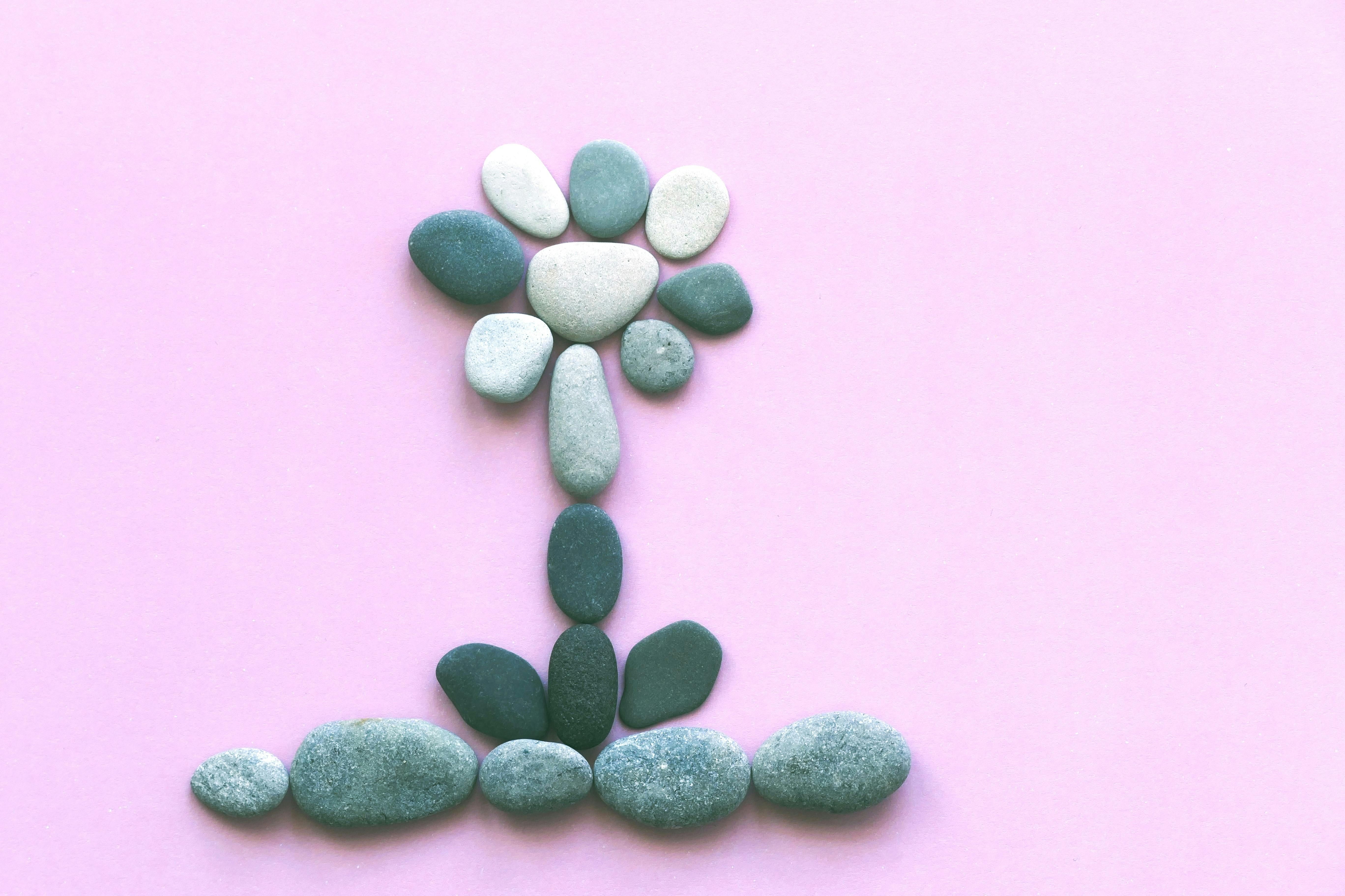 Stones on Pink Background Representing Kidney Stones and Diet Management Close-up image of stones on a pink background symbolizing kidney stones, highlighting the importance of diet in kidney health.