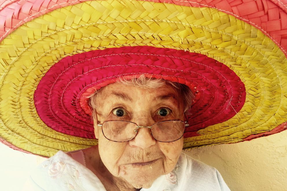 Older lady in a colored hat enjoys her active longevity Older happy lady enjoys longevity