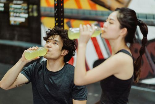 The 2024 Guide to Electrolytes for Women: How to Stay Hydrated and Energized Naturally A woman replenishing electrolytes naturally with a drink after a workout, supporting hydration and muscle recovery.