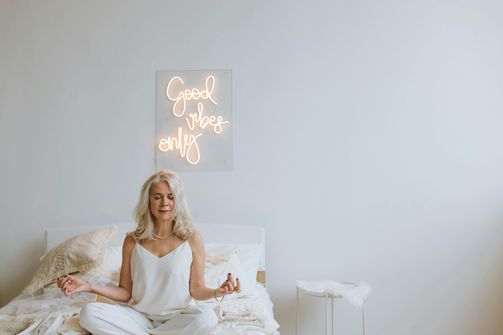 The 2024 Guide to Better Sleep and Menstrual Health for Women A woman creating a restful sleep environment to balance hormones and improve menstrual health.