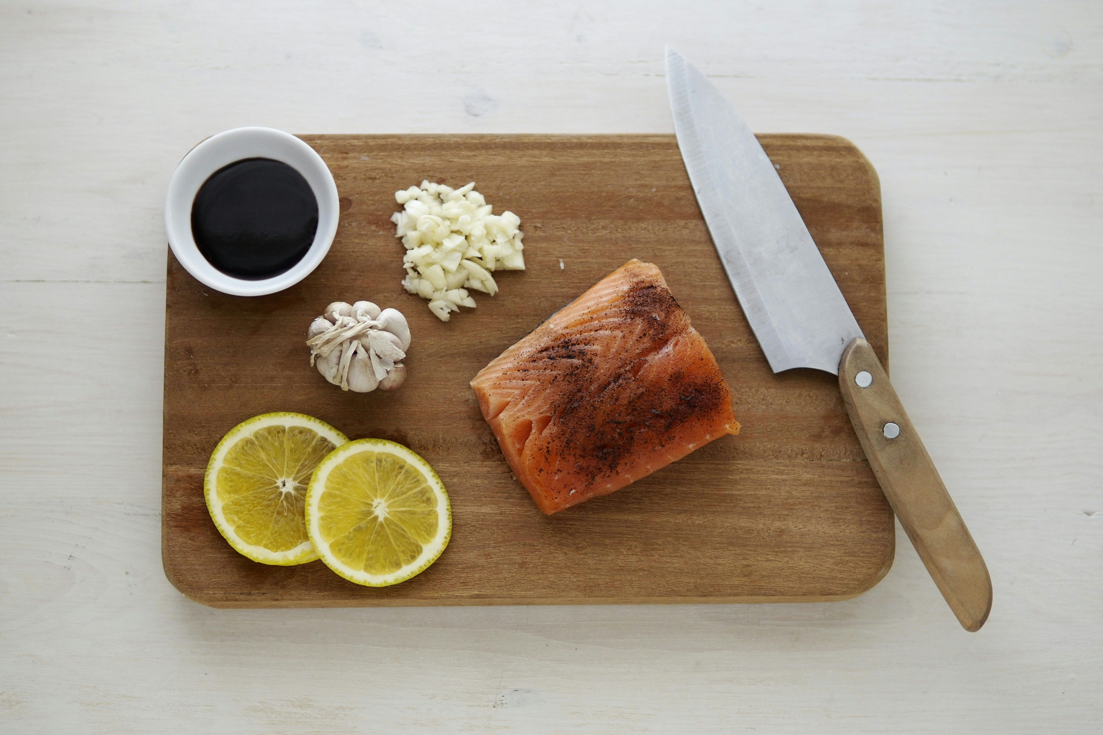 A woman preparing a Ketovore meal featuring salmon A woman cooking a Ketovore meal with fish
