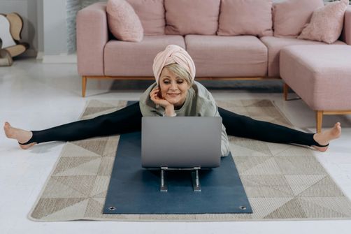 Woman stretching at home to live longer and happier Woman stretching at home